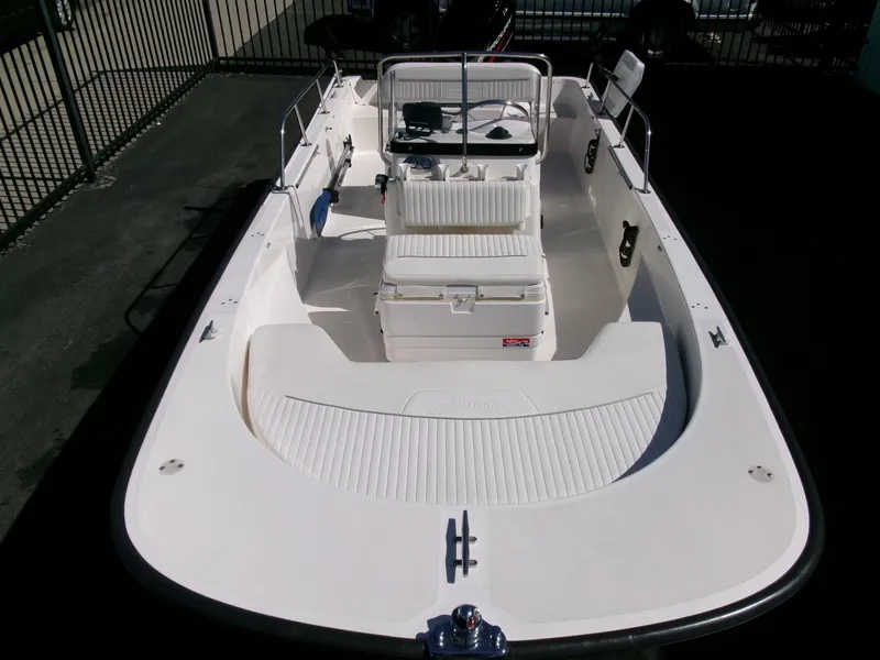 Slide: The Image of 2003 Boston Whaler 170 Montauk boat, white interior, open deck, center console, parked outdoors. - 24