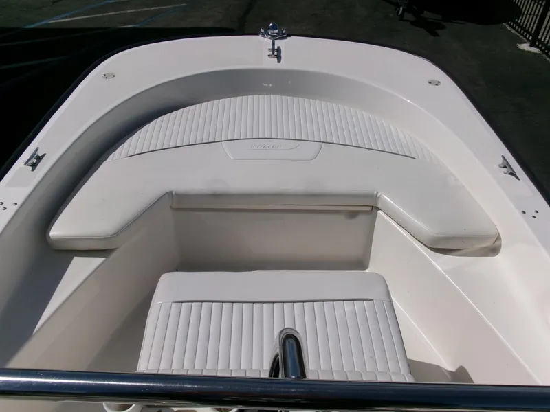 Slide: The Image of 2003 Boston Whaler 170 Montauk boat interior with white seating and stainless steel railing. - 4