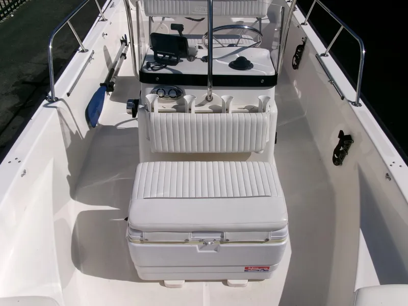 Slide: The Image of 2003 Boston Whaler 170 Montauk boat interior with white seating and steering console. - 7