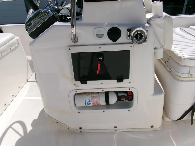 Slide: The Image of 2003 Boston Whaler 170 Montauk console with fire extinguisher and storage compartment. - 9