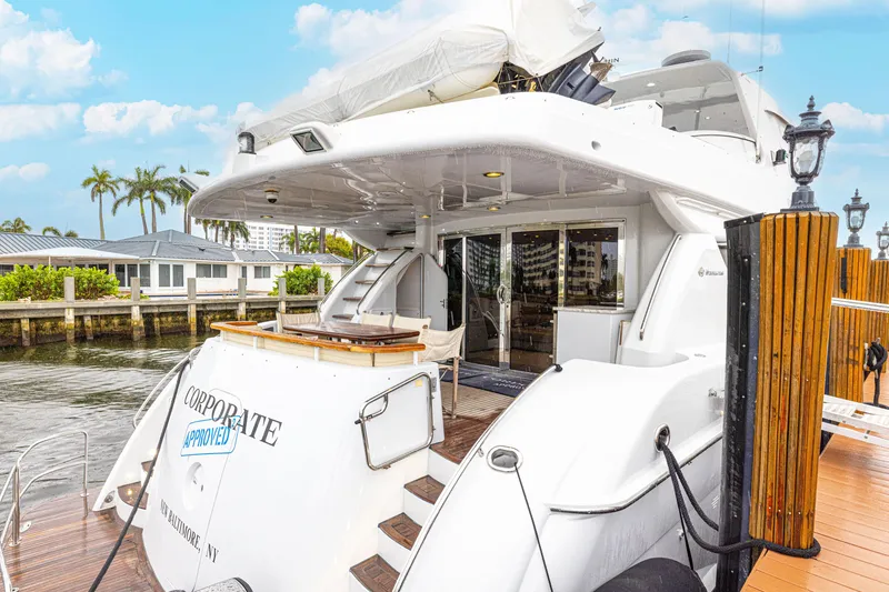 Slide: The Image of 2005 Hatteras 80 Motor Yacht docked, featuring spacious deck and elegant design. - 16