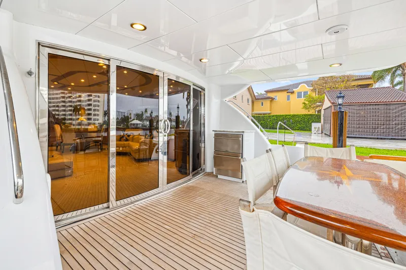 Slide: The Image of Luxurious 2005 Hatteras 80 Motor Yacht deck with elegant seating and glass doors. - 18