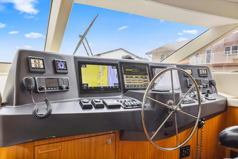 Slide: The Image of Helm of 2005 Hatteras 80 Motor Yacht with navigation equipment and steering wheel. - 44