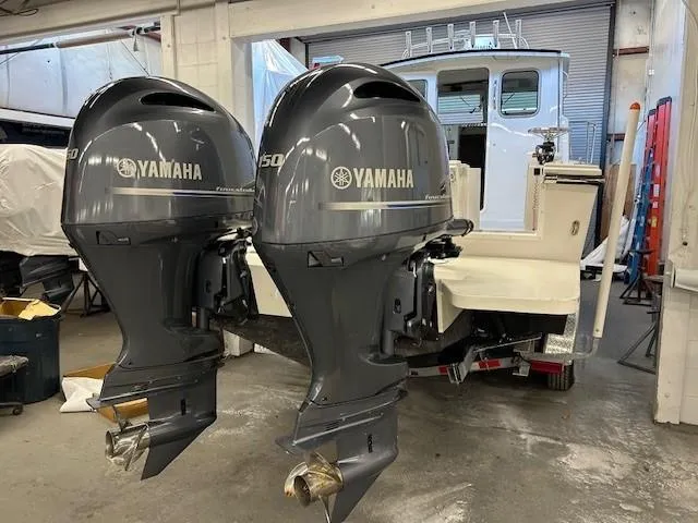 Slide: The Image of 2022 Parker 2520 XLD Sport Cabin with twin Yamaha outboard motors in a garage. - 21