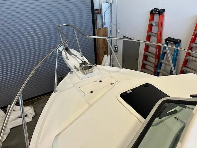 Slide: The Image of 2022 Parker 2520 XLD Sport Cabin boat bow in a garage with ladders. - 4
