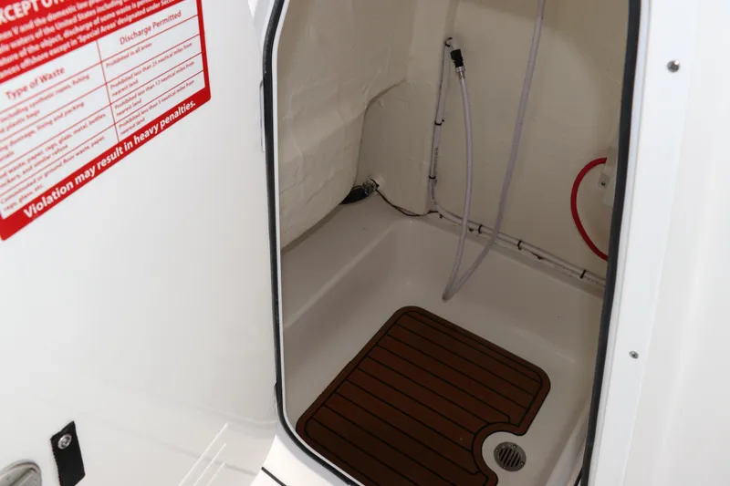Slide: The Image of 2024 Tidewater 232 CC Adventure boat interior shower area with wooden floor mat. - 14