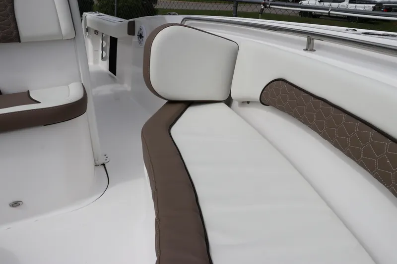 Slide: The Image of 2024 Tidewater 232 CC Adventure boat interior with white and brown cushioned seating. - 17