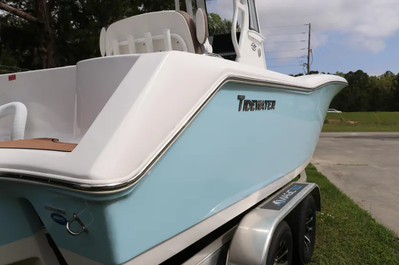 Slide: The Image of 2024 Tidewater 232 CC Adventure boat on trailer, featuring sleek blue and white design. - 2