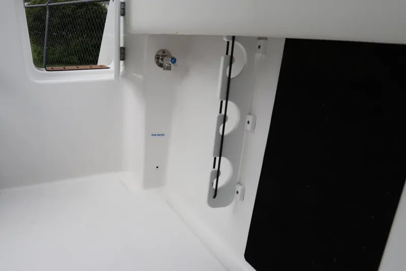 Slide: The Image of 2024 Tidewater 232 CC Adventure boat interior with rod holders and storage space. - 6