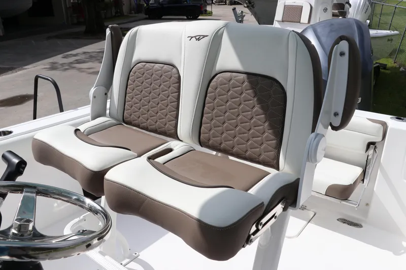 Slide: The Image of 2024 Tidewater 232 CC Adventure boat seats with quilted design and steering wheel. - 9