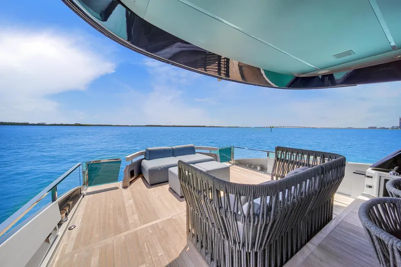 Slide: The Image of Luxurious Explorer 62 yacht deck with modern seating, overlooking serene blue waters, 2021 model. - 10