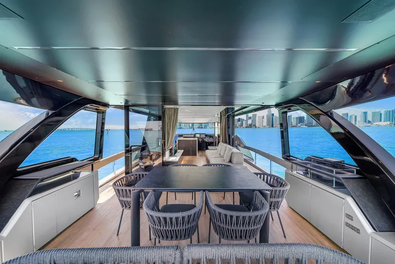 Slide: The Image of Luxurious 2021 Explorer 62 yacht interior with dining area, overlooking ocean and city skyline. - 11