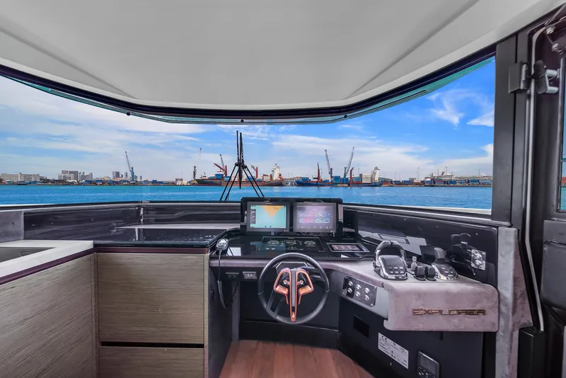 Slide: The Image of Cockpit view of 2021 Explorer 62 yacht with modern navigation equipment and ocean backdrop. - 29