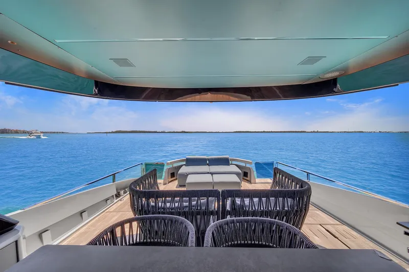 Slide: The Image of Luxury Explorer 62 yacht deck with ocean view, 2021 model, featuring elegant seating and clear blue skies. - 35