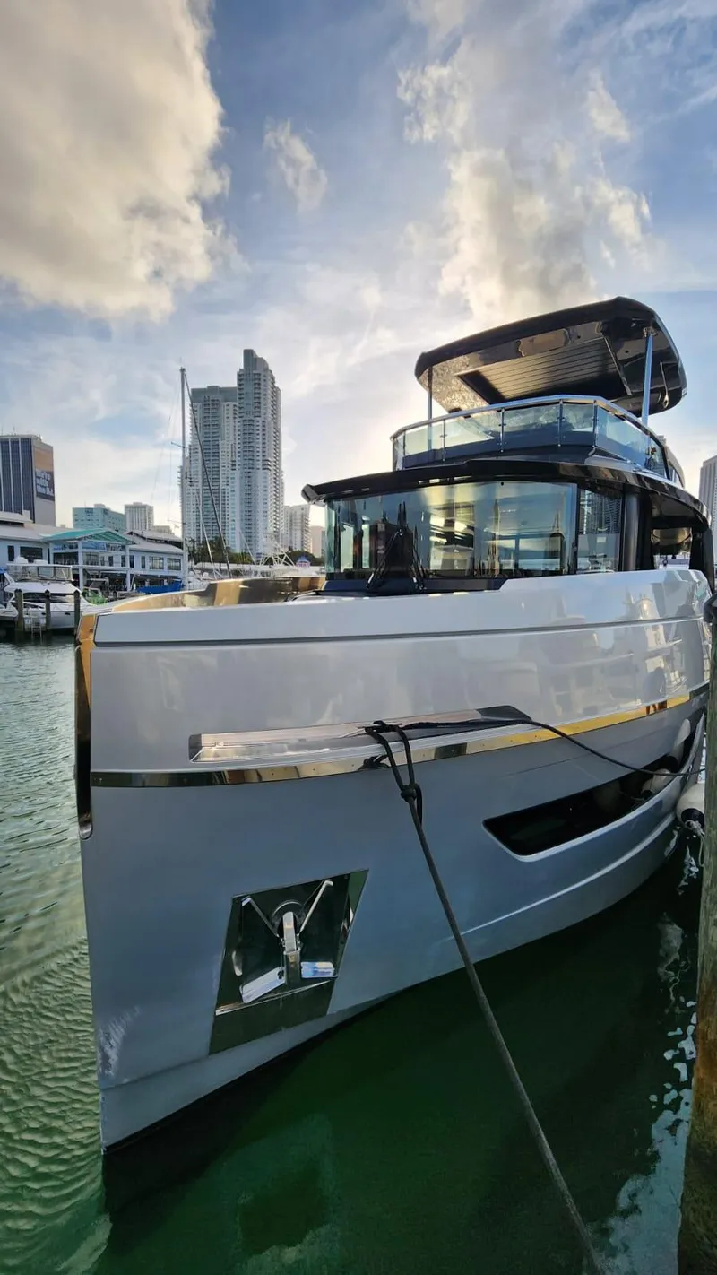 Slide: The Image of Luxury Explorer 62 yacht docked in urban marina, 2021 model, with city skyline backdrop. - 4