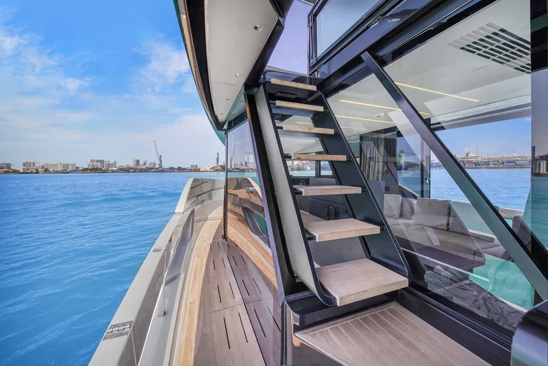 Slide: The Image of Modern Explorer 62 yacht deck with stairs, overlooking serene blue waters, 2021 model. - 45