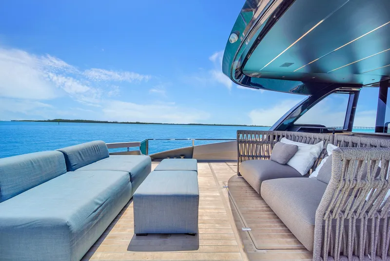 Slide: The Image of Luxurious Explorer 62 yacht deck with modern seating, overlooking serene blue ocean, 2021 model. - 9