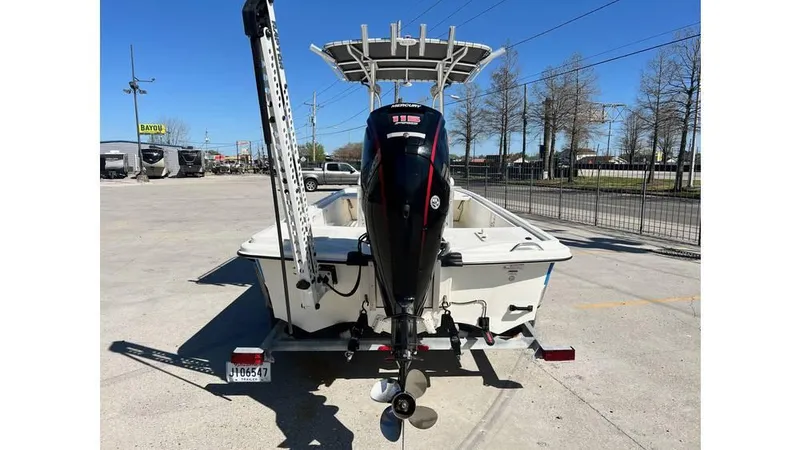 Slide: The Image of 2018 Mako Pro Skiff 19 CC boat with outboard motor, parked in a lot. - 11
