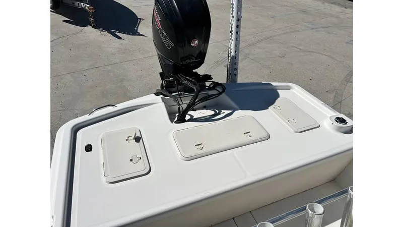 Slide: The Image of 2018 Mako Pro Skiff 19 CC boat with outboard motor and storage compartments. - 2