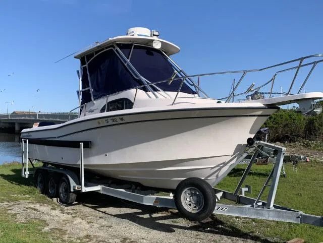 Slide: The Image of 2005 Grady-White 282 Sailfish boat on trailer, parked outdoors under clear blue sky. - 0