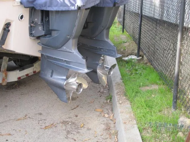 Slide: The Image of Twin outboard motors on a 2005 Grady-White 282 Sailfish boat, parked near a fence. - 21