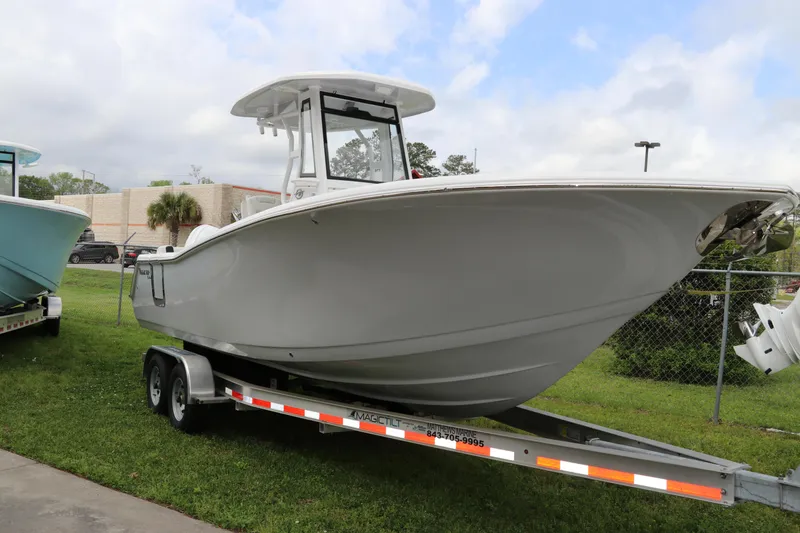The Image of 2024 Tidewater 256 LXF boat on trailer, parked on grass, under cloudy sky. - 0