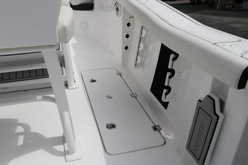 Slide: The Image of 2024 Tidewater 256 LXF boat interior, featuring sleek white deck and seating area. - 10