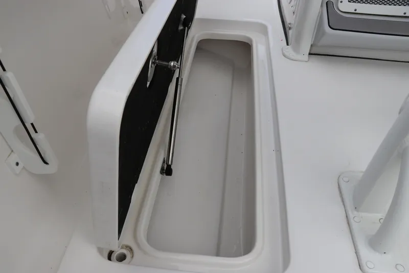 Slide: The Image of 2024 Tidewater 256 LXF boat storage compartment with open lid. - 11