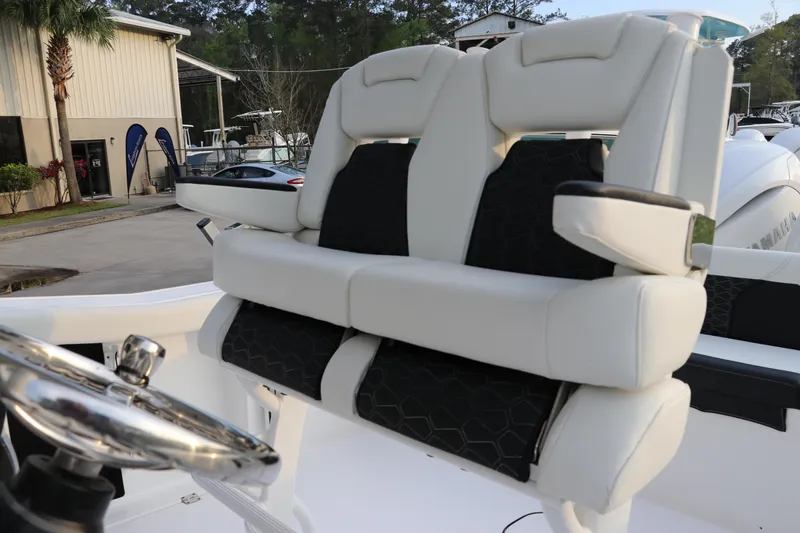 Slide: The Image of 2024 Tidewater 256 LXF boat with luxurious white and black seating at the helm. - 19