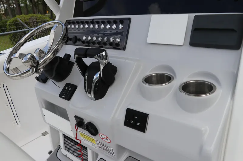 Slide: The Image of 2024 Tidewater 256 LXF boat console with steering wheel and controls. - 22
