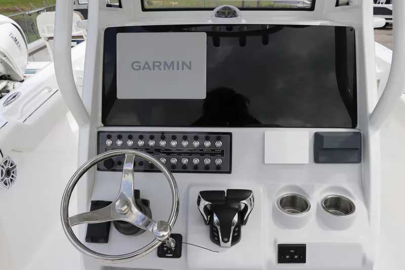Slide: The Image of 2024 Tidewater 256 LXF boat dashboard with Garmin display and controls. - 23