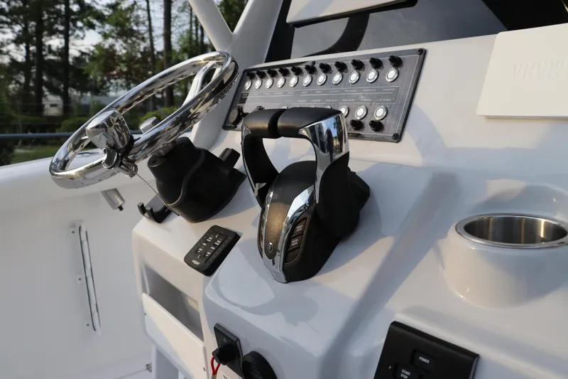Slide: The Image of 2024 Tidewater 256 LXF boat dashboard with steering wheel and controls. - 25