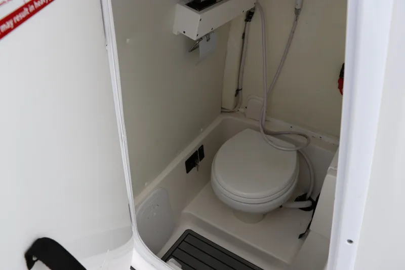 Slide: The Image of 2024 Tidewater 256 LXF boat interior with compact marine toilet and shower. - 27