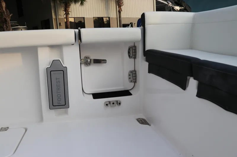 Slide: The Image of 2024 Tidewater 256 LXF boat interior with footrest and storage compartment. - 3