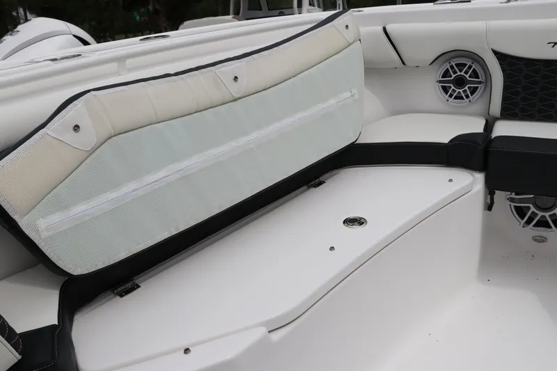 Slide: The Image of 2024 Tidewater 256 LXF boat interior with cushioned seating and speaker system. - 36