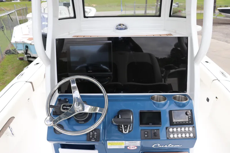 Slide: The Image of 2024 Tidewater 2500 Carolina Bay boat dashboard with steering wheel and control panel. - 11