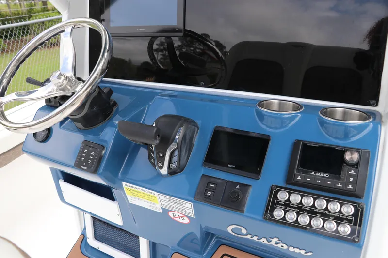 Slide: The Image of 2024 Tidewater 2500 Carolina Bay boat dashboard with steering wheel and electronic controls. - 12