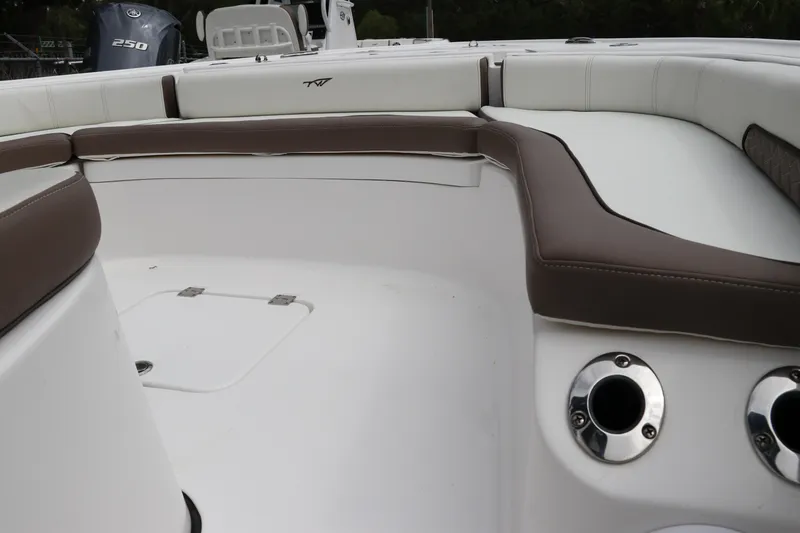 Slide: The Image of 2024 Tidewater 2500 Carolina Bay boat interior with cushioned seating and rod holders. - 21