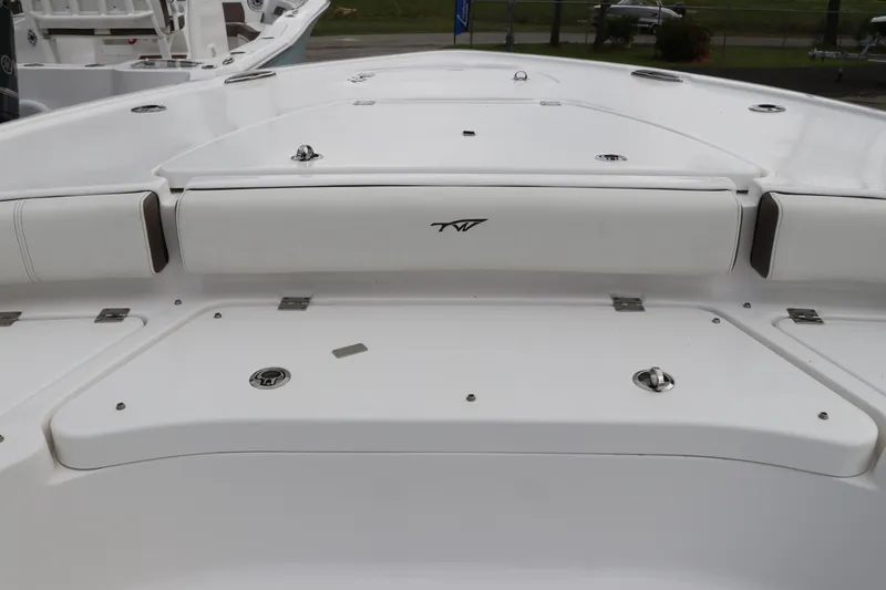 Slide: The Image of 2024 Tidewater 2500 Carolina Bay boat deck, featuring sleek white design and storage compartments. - 23