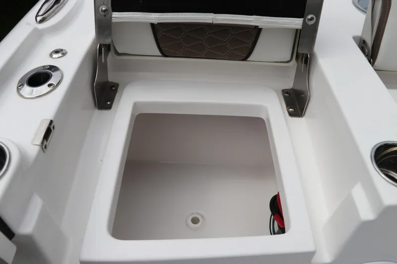 Slide: The Image of 2024 Tidewater 2500 Carolina Bay boat storage compartment with cup holders and seating. - 5