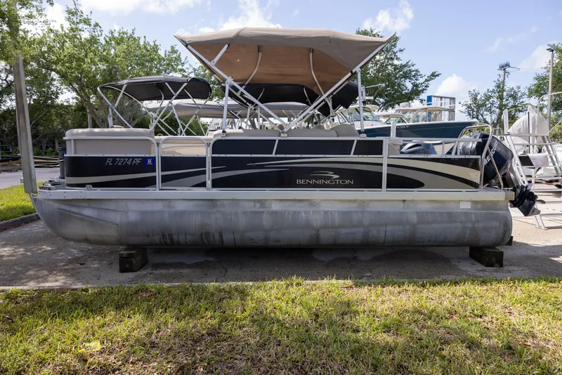 Slide: The Image of 2012 Bennington 22 SSL pontoon boat with canopy, parked on a sunny day. - 0