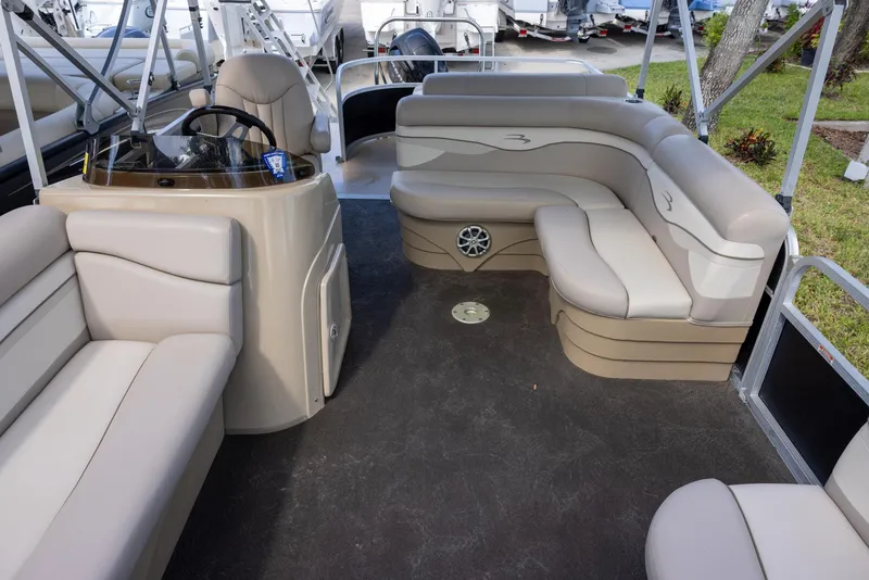 Slide: The Image of 2012 Bennington 22 SSL pontoon boat interior with beige seating and steering console. - 11