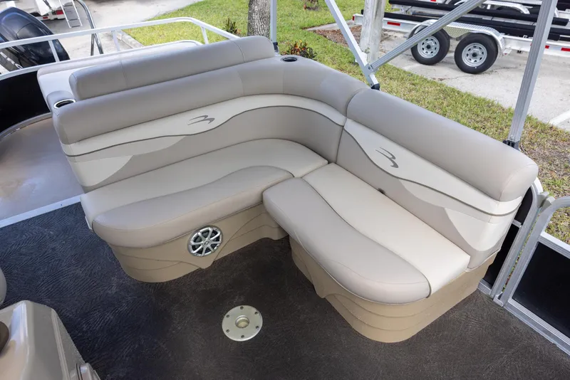 Slide: The Image of 2012 Bennington 22 SSL boat interior with beige seating and speaker. - 7