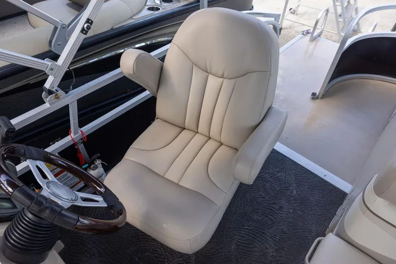 Slide: The Image of Captain's chair on a 2012 Bennington 22 SSL boat, featuring a sleek steering wheel. - 8
