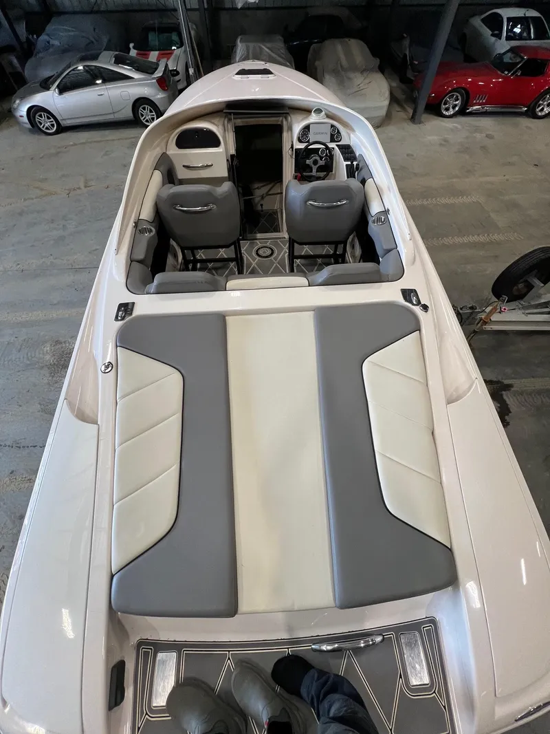 Slide: The Image of 1997 Donzi 27 ZX boat interior with gray and white seating, parked in a garage. - 9