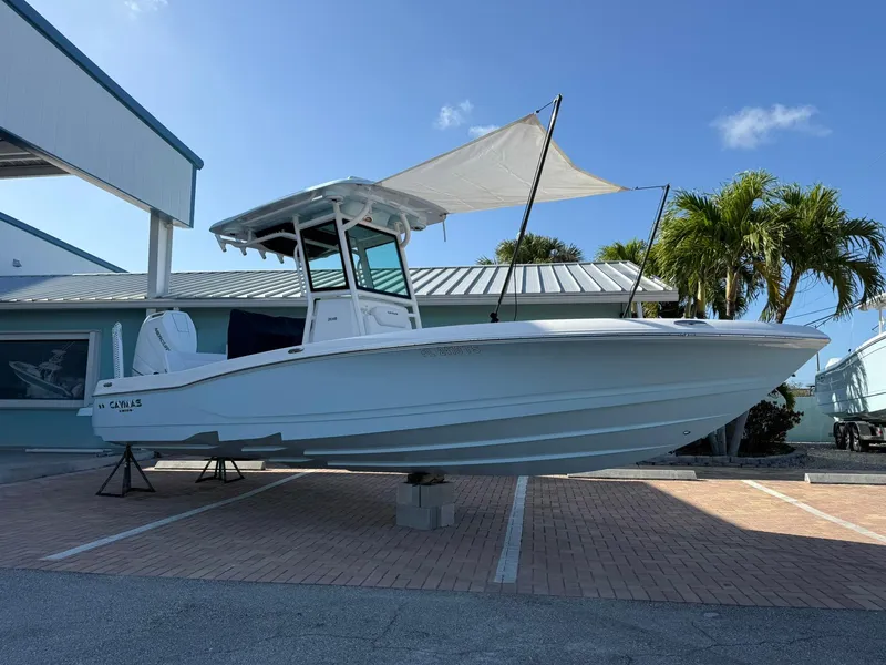 The Image of 2024 Caymas 26 HB boat displayed outdoors with palm trees and blue sky background. - 0