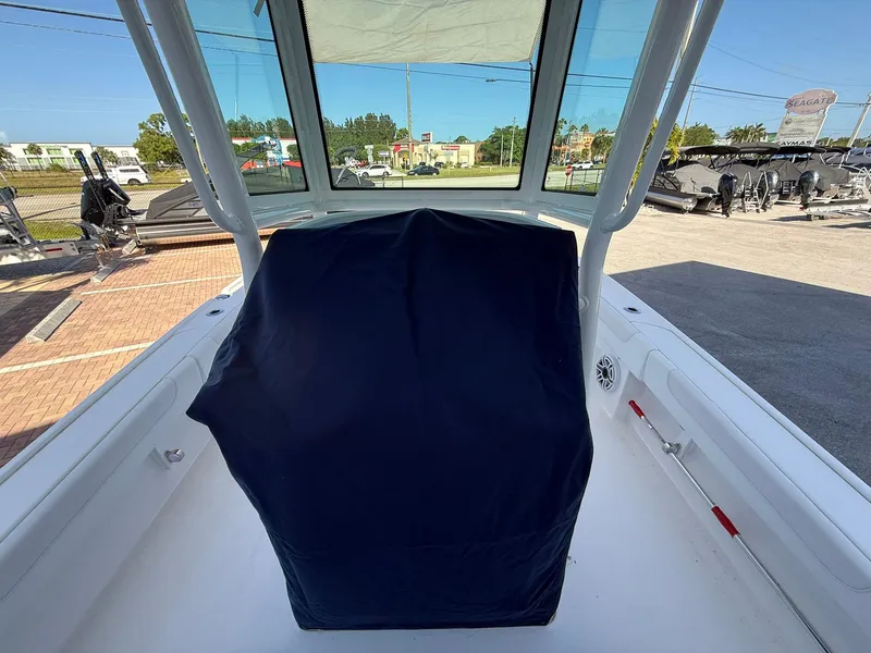 Slide: The Image of 2024 Caymas 26 HB boat interior with covered console, outdoor setting. - 12