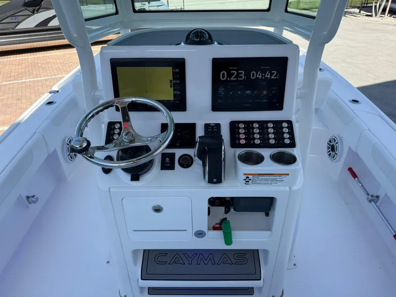 Slide: The Image of 2024 Caymas 26 HB boat dashboard with steering wheel, digital displays, and control panel. - 14