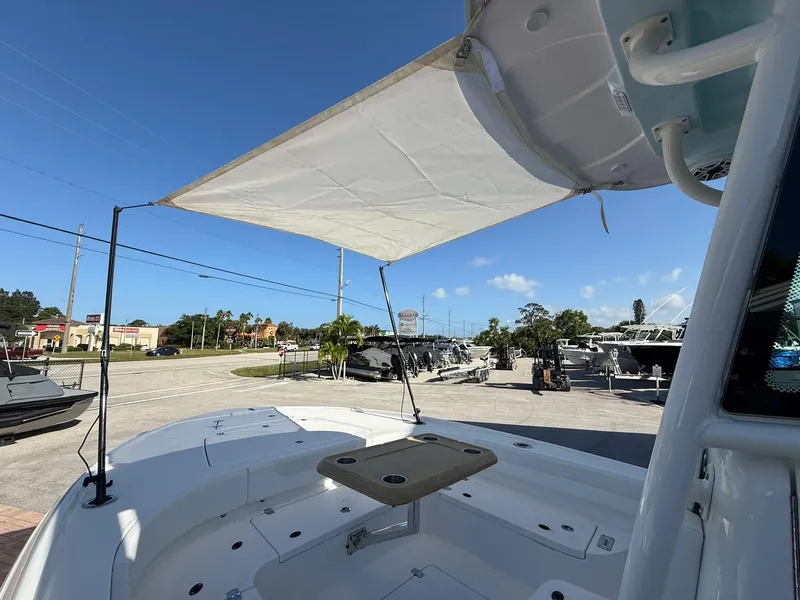 Slide: The Image of 2024 Caymas 26 HB boat with sunshade, docked under clear blue sky. - 22
