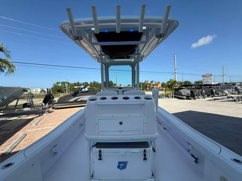 Slide: The Image of 2024 Caymas 26 HB boat interior with console and T-top under clear blue sky. - 8